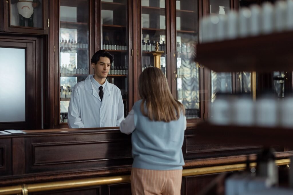 Pharmacien conseillant une cliente au comptoir d'une officine
